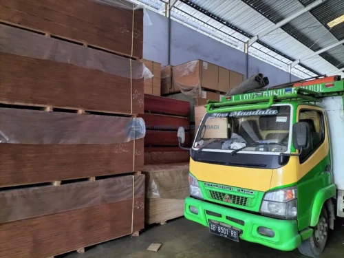 Tumpukan rapi plywood lantai kontainer 28mm di dalam gudang PT Indoho Santosa Abadi siap dimuat ke armada truk pengiriman